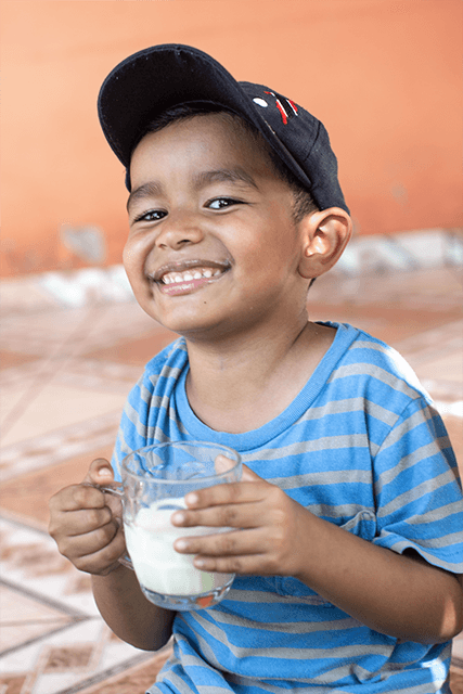 Hector (5) drinks a cup of milk from his father's cow in Honduras